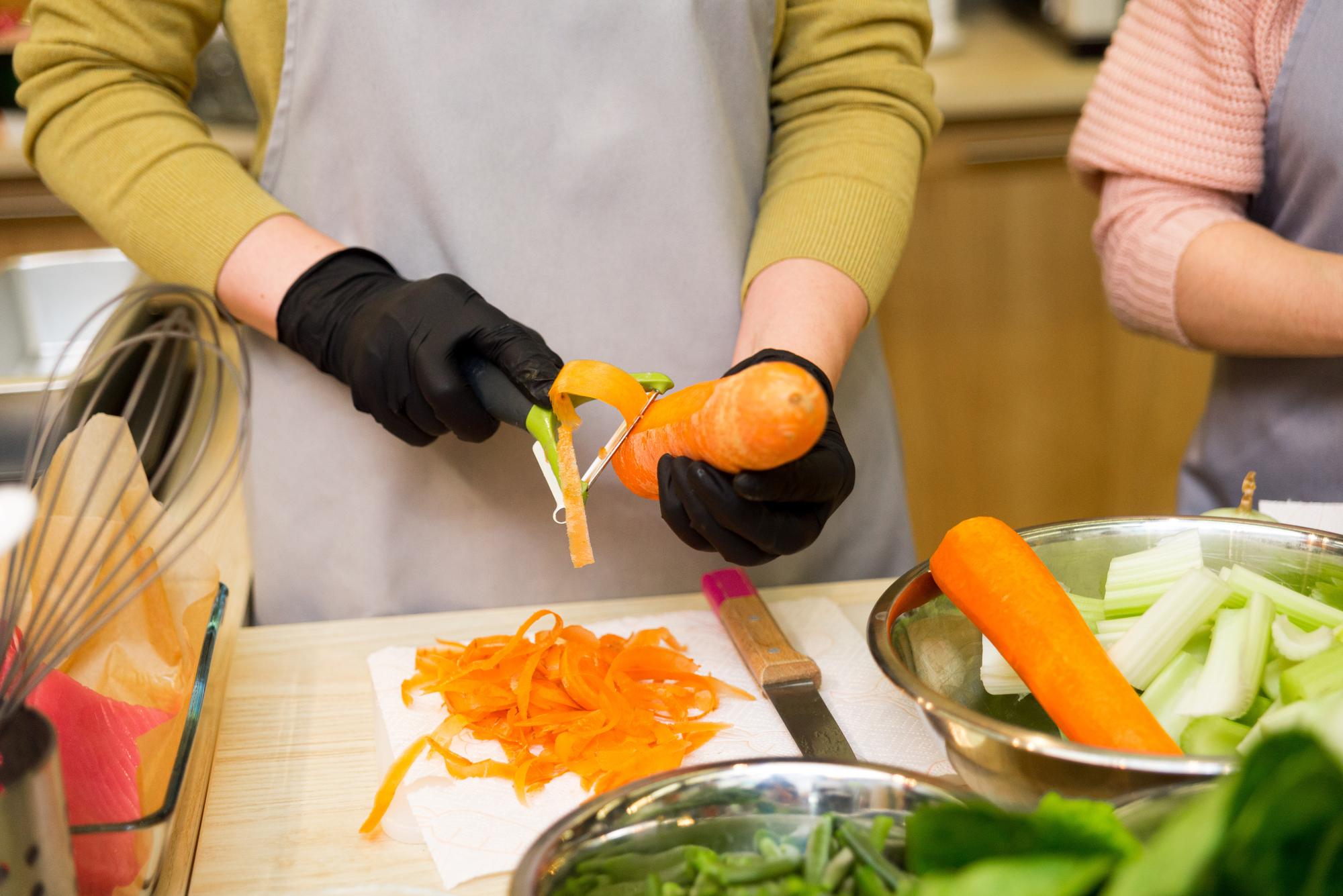 Studente che impara a tagliare verdure con tecnica